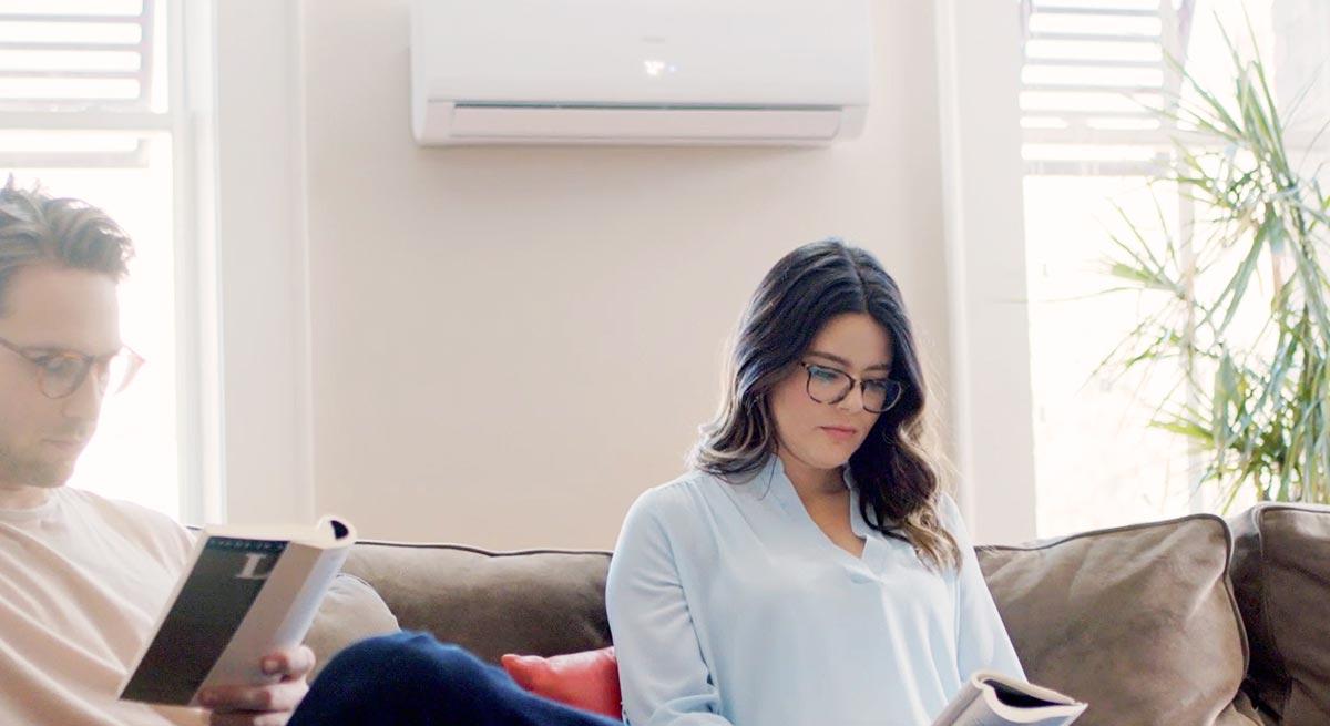 Photo of Haier Ductless Wall Mount AC Installed in Home, Homeowners Reading Nearby Photo of Haier Ductless Wall Mount AC Installed in Home, Homeowners Reading Nearby